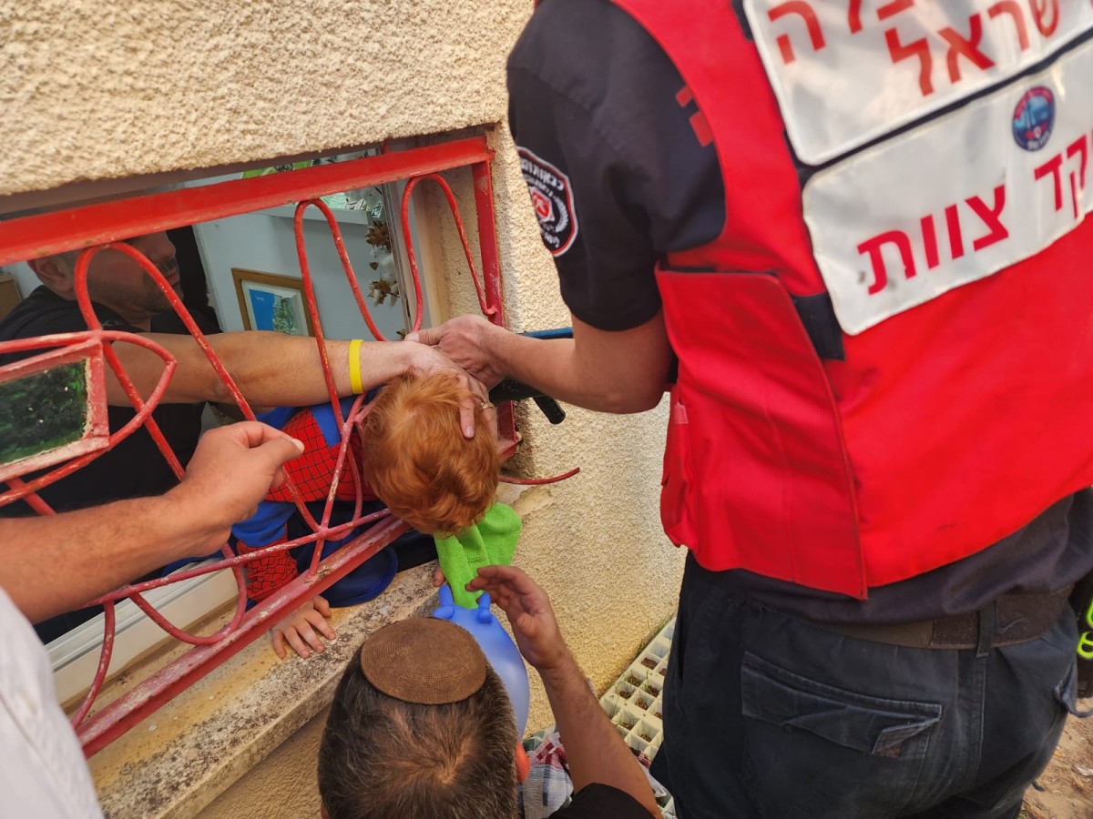 חילוץ הילד שראשו נתקע בין סורגים | צילום: דוברות כבאות והצלה